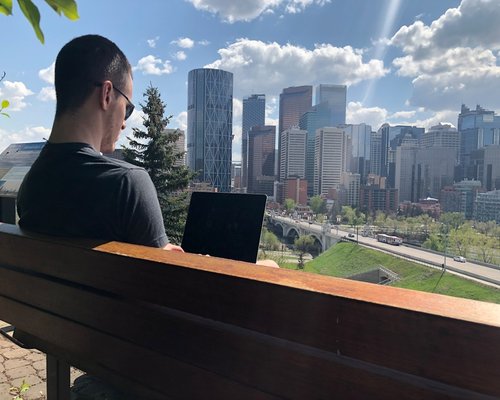 A person looking away from their computer screen towards a city view during a break